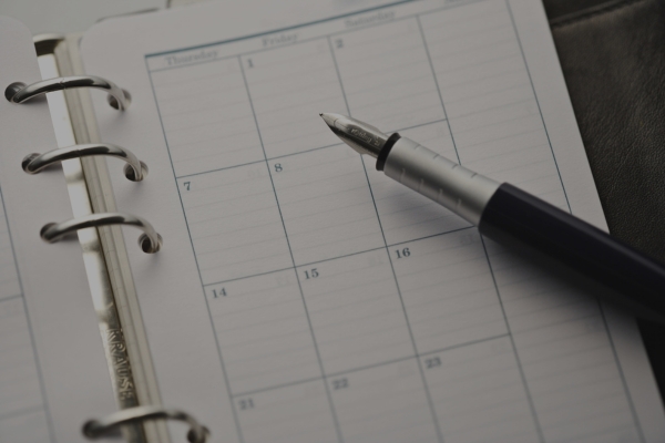 A pen marking a date on a calendar.