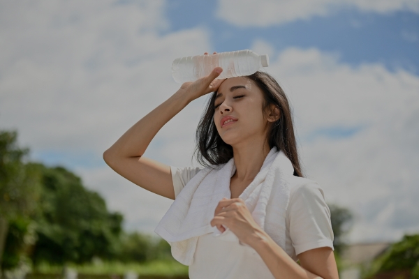 Marathon runner cooling down with a water bottle on their forehead.