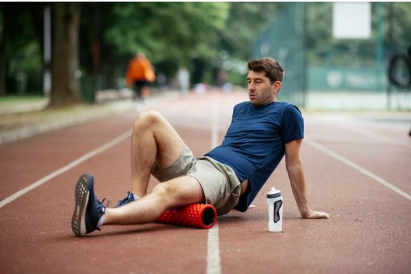 Athlete using foam roller on legs post-marathon