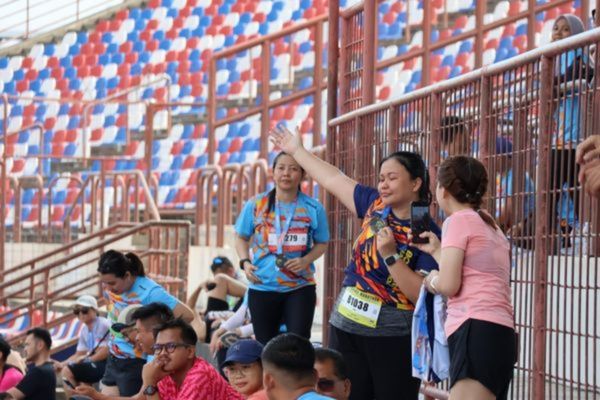 Happy runners posing mid-race with thumbs up.