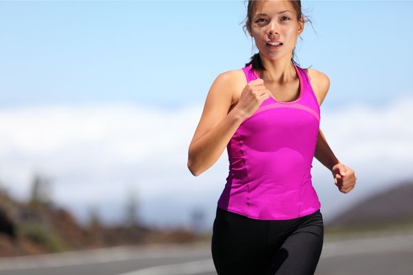 A runner training in the heat of midday to prepare for a marathon.