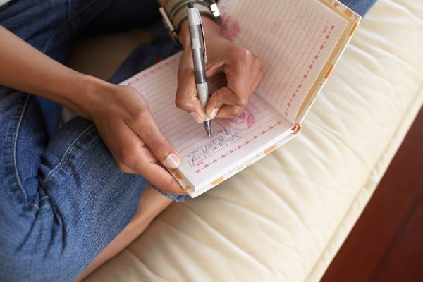 A runner writing notes in a journal after a run.