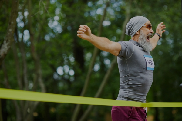 Marathon runner celebrating at the finish line.