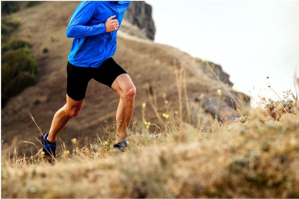 A marathon runner power walking uphill to conserve energy.