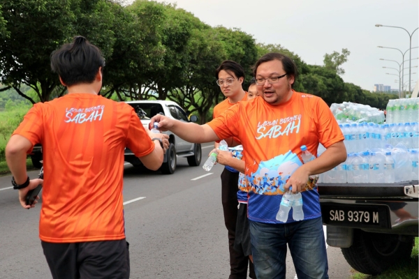 A marathon runner hydrating during a hot weather run.