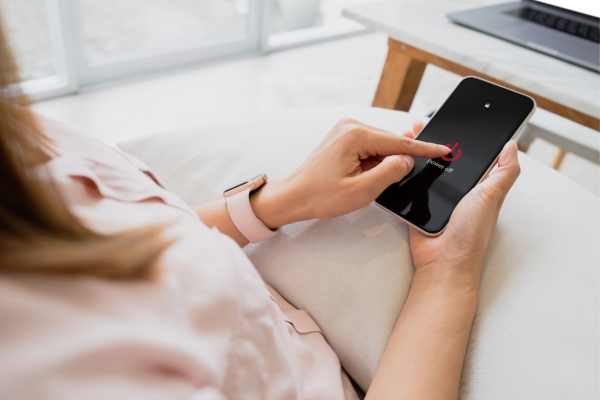 Hands turning off a smartphone, symbolizing a digital detox for marathon training.