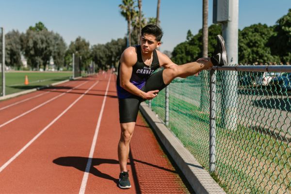 A runner stretches their calves before running to prevent Achilles tendonitis