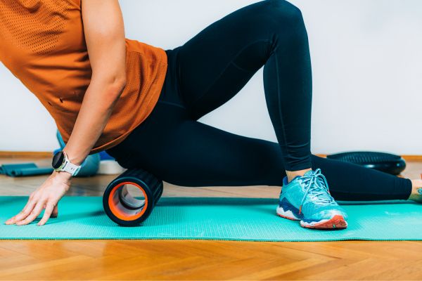 A runner using a foam roller to stretch their IT band and prevent injury