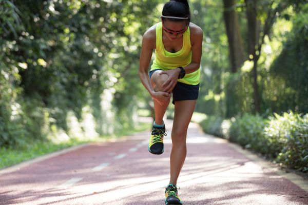 A runner massages their shin muscles to relieve shin split pain