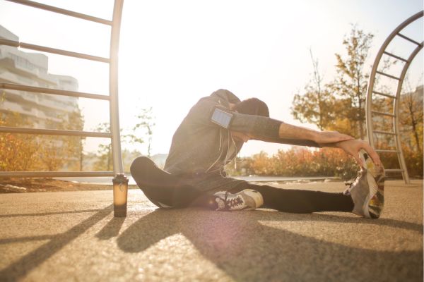 A runner performing a quad stretch to reduce the risk of runner's knee