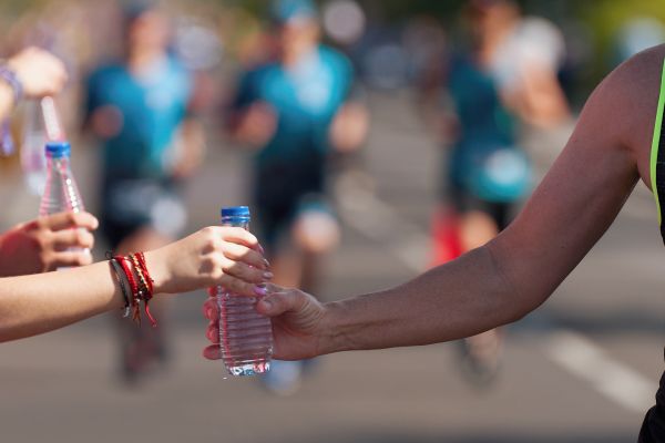 Volunteers giving water to runners at Borneo International Marathon